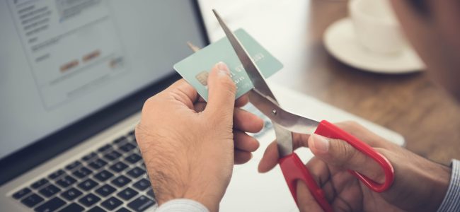 Empresário corta cartão  de crédito no ambiente de trabalho